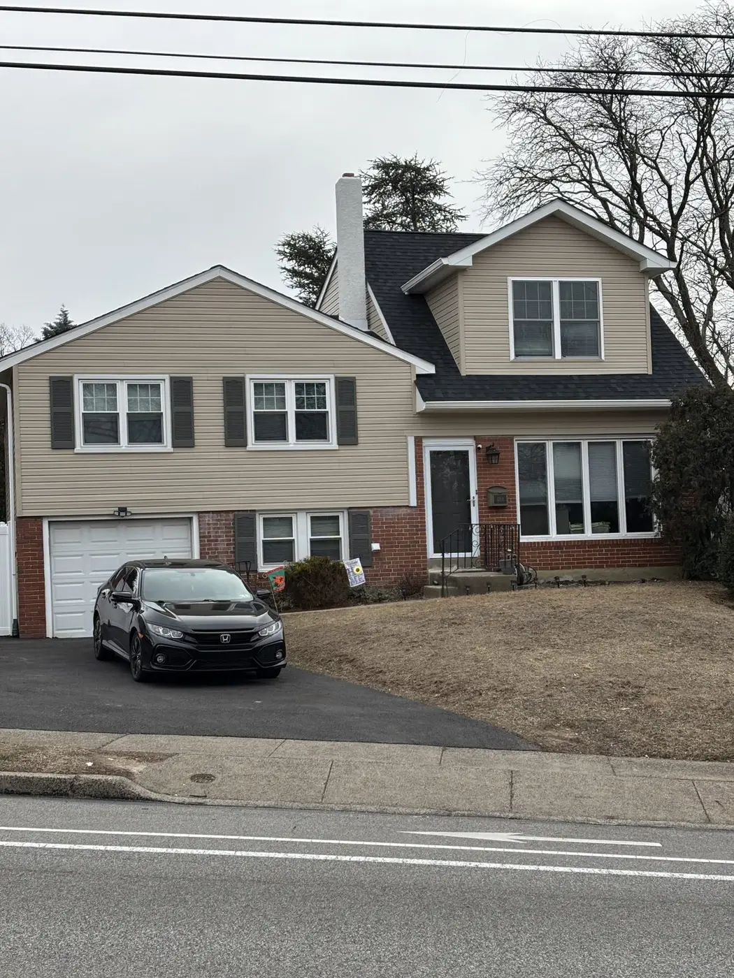 Finished front of the Abington split-level with the new third-story gable and dormer, a car in the driveway