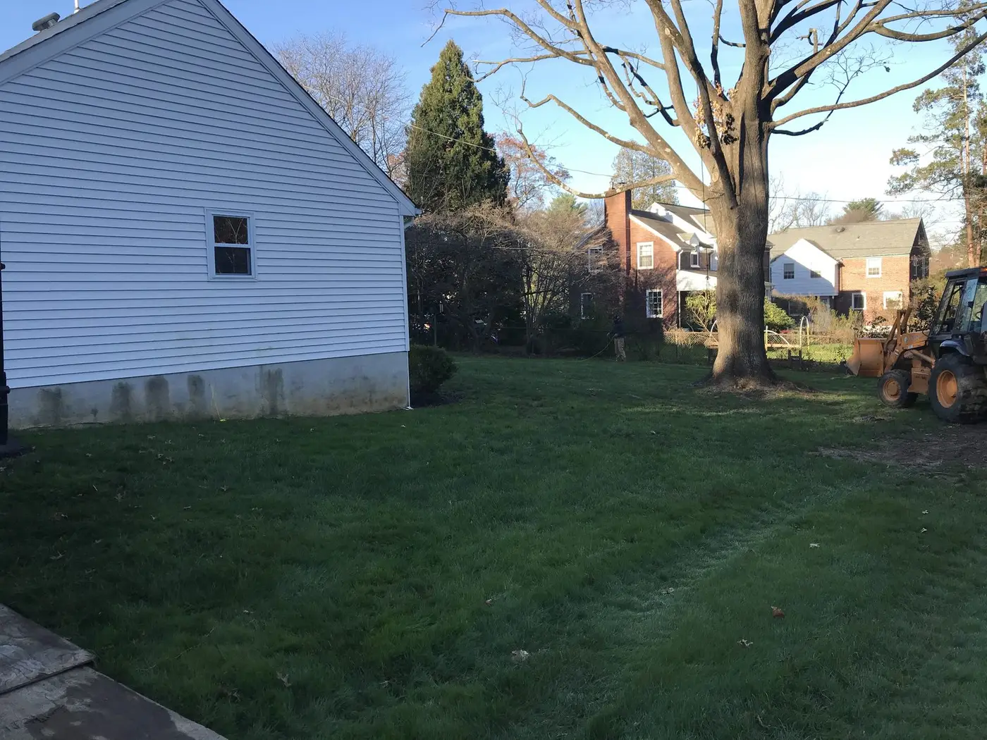 Side yard beside a white house in Wyndmoor, PA, where an in-law suite and garage were later built