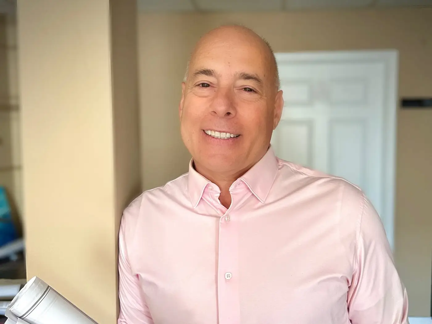 Dan DeSantis, president of Giuliani Builders, holding a roll of house plans